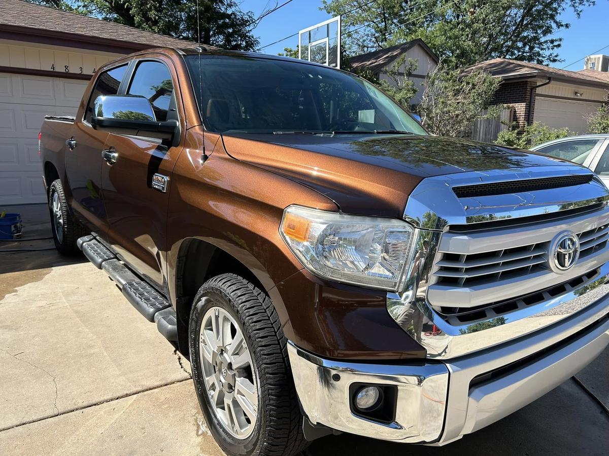 Outside: a brown Toyota Tundra from the front three-quarter, on a driveway