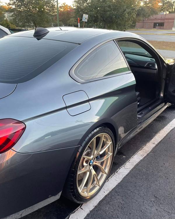 A gray BMW coupe, rear three-quarter