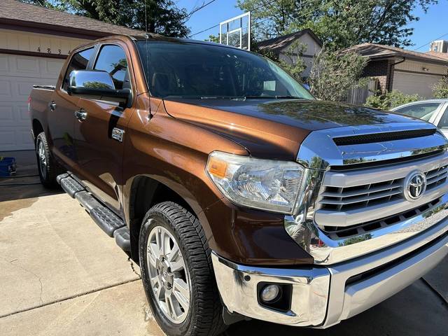 A brown Toyota Tundra, front three-quarter, on a driveway